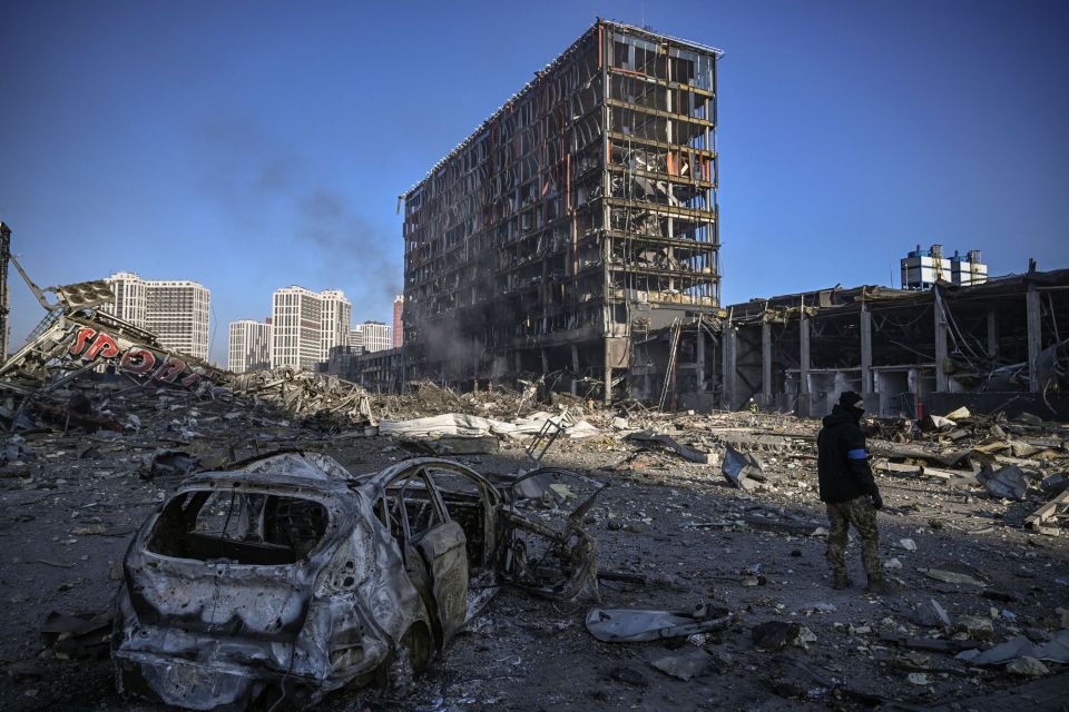 A Ukranian serviceman walks between debris outside a destroyed shopping mall in Kyiv