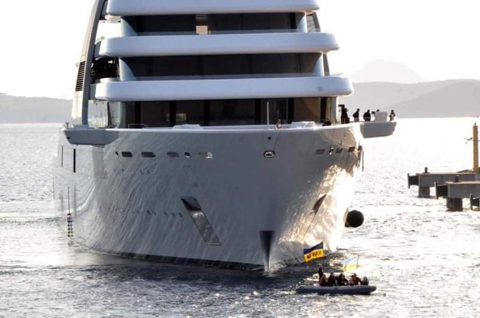 The Ukrainians protesting in a tiny boat beside the huge yacht