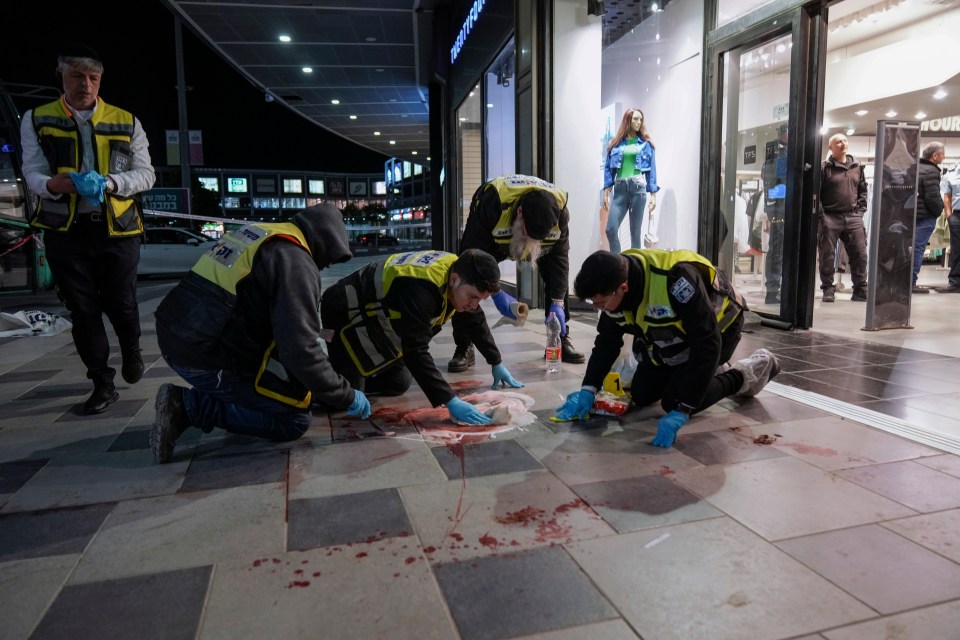 Members of Israel's ZAKA emergency and response team clean blood stains at the scene