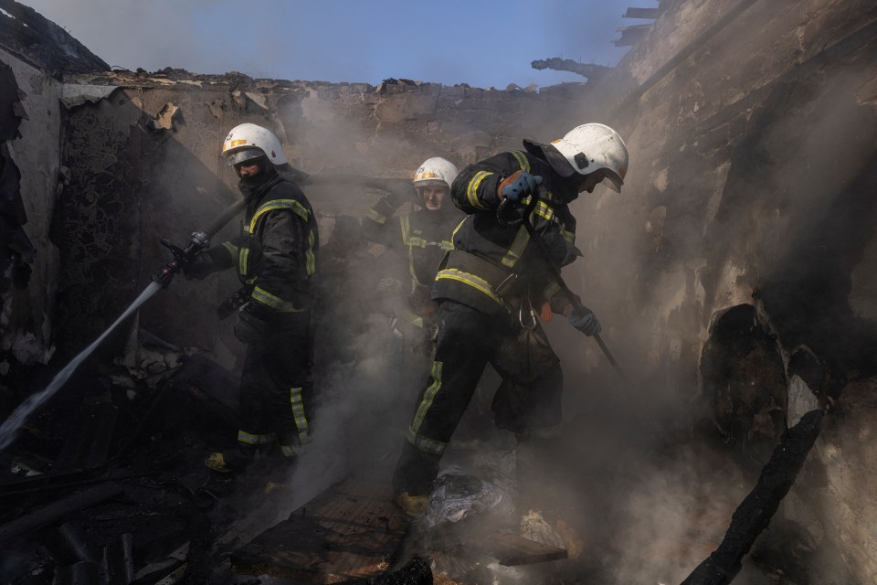 Firefighters works at a residential district that was damaged by shelling in Kyiv