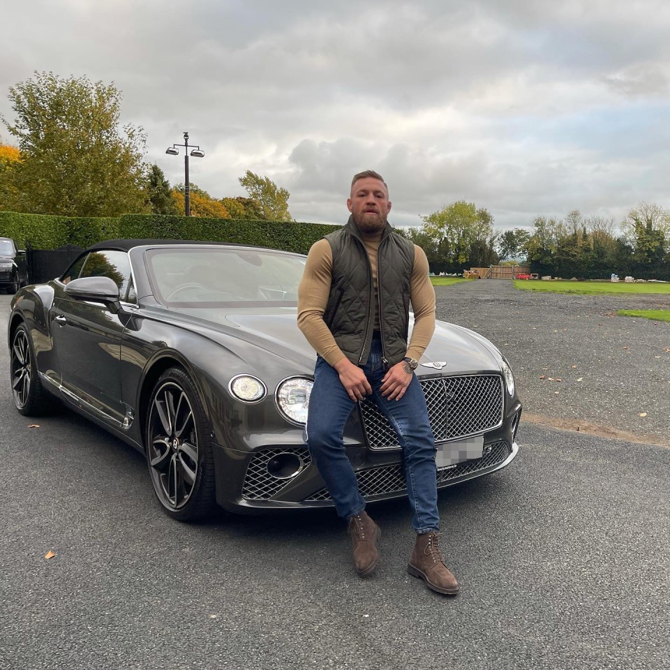 Conor McGregor posing next to his Bentley convertible