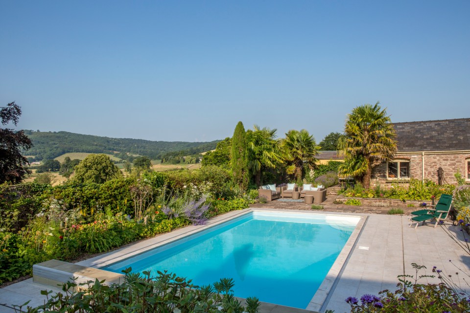 Outside, the heated pool is surrounded by palm trees and honeysuckle