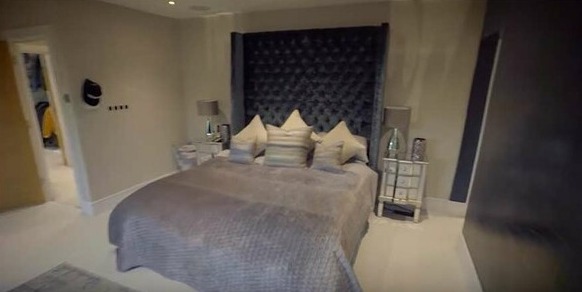 The master bedroom features a huge bedframe that nearly touches the ceiling