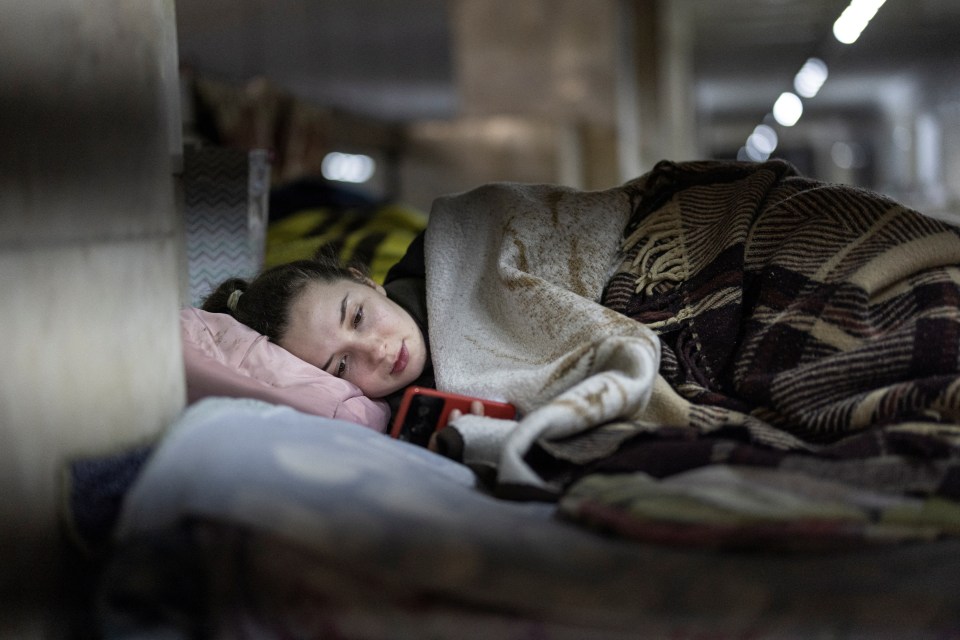 Masha, 26, checks her mobile phone at a metro station that serves as a shelter from possible air raids in the capital