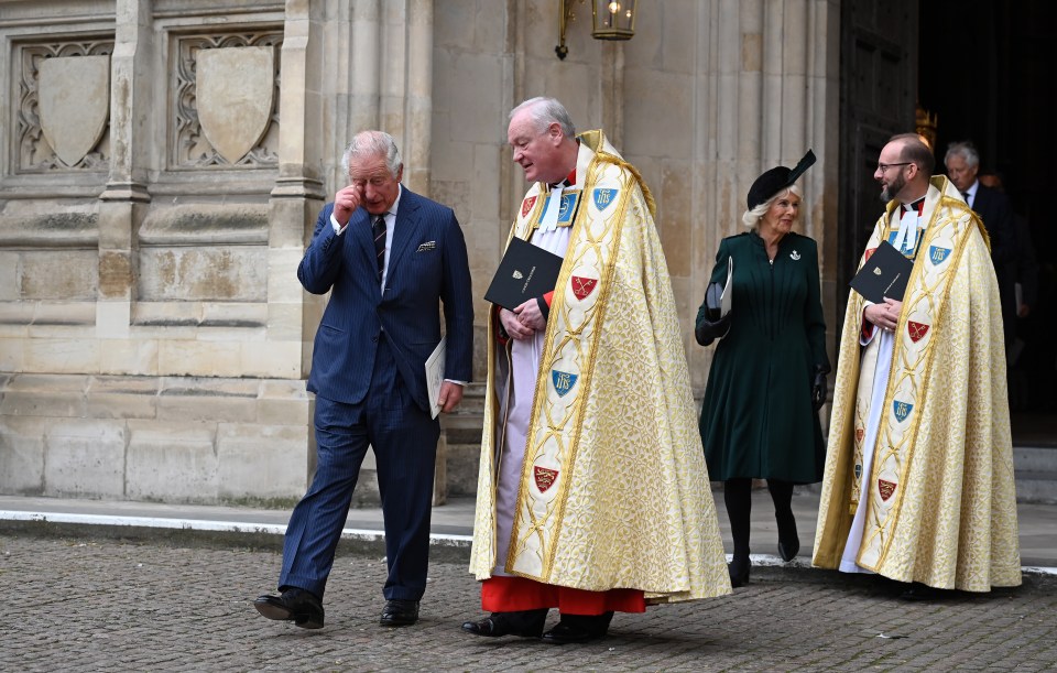 Charles bowed his head while clutching a programme as he left the Abbey