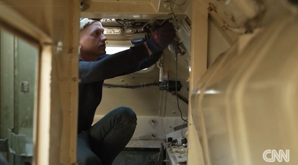 A Ukrainian mechanic working on a captured Russian tank