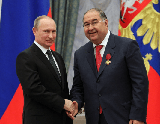 Alisher Usmanov, pictured with Putin, has been hit by sanctions  tonight in the latest Kremlin hit