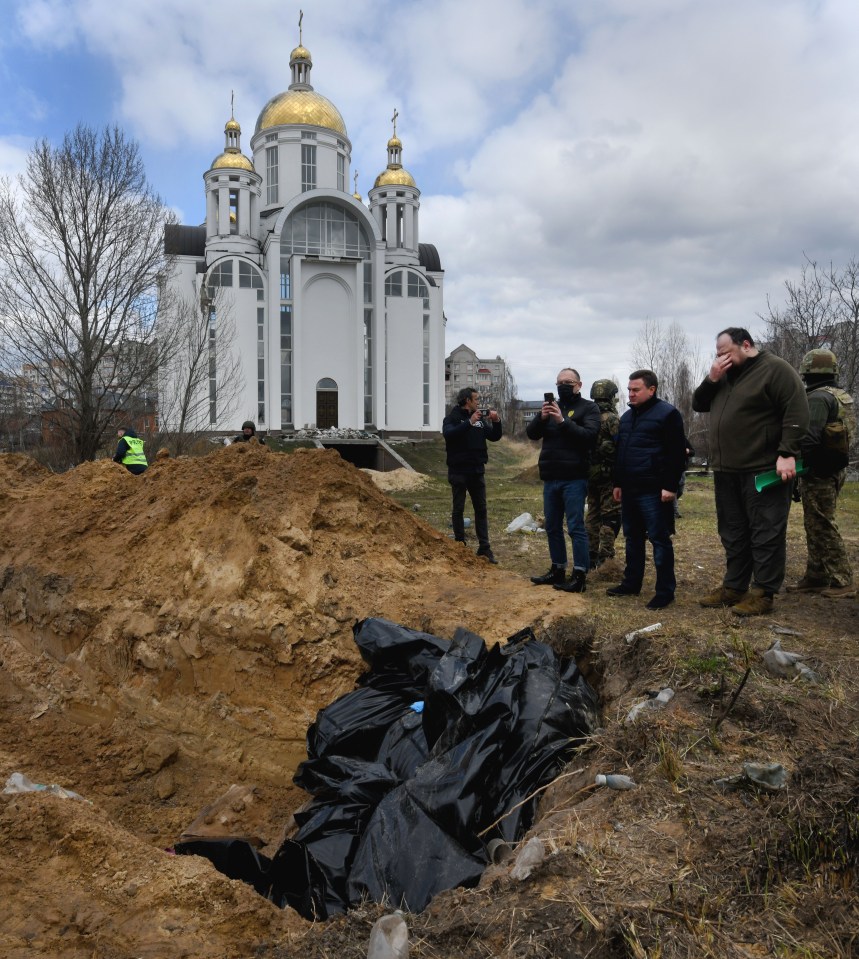 Black body bags filled an open trench in the town of Bucha