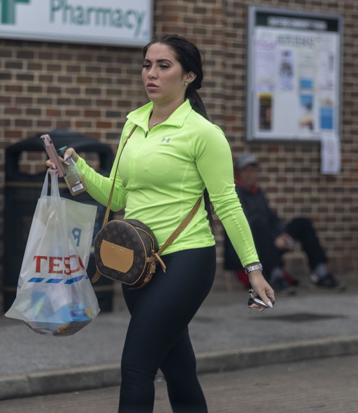 She dressed down for her visit to the shops but couldn't be missed in a neon green gym top