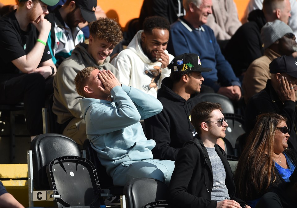 The youngster covers his face as he and friends laugh while watching Barnet vs Southend