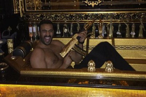 Ramzan Kadyrov's pal kickboxer Badr Hari poses with the warlord's  golden AK-47 in a golden bathtub