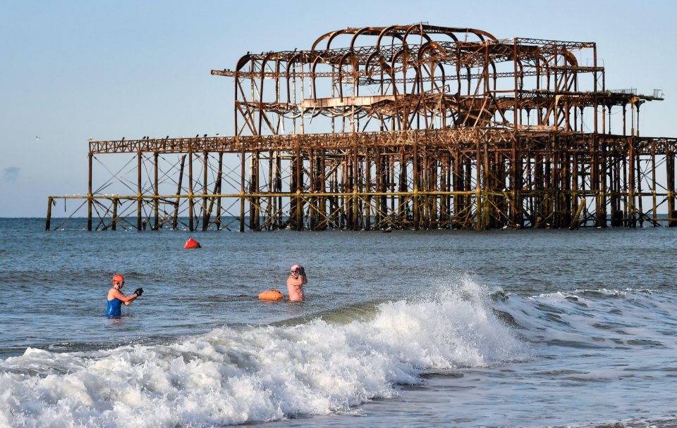 Swimmers brave the freezing temperatures as they take a dip in the sea by Brighton's West Pier