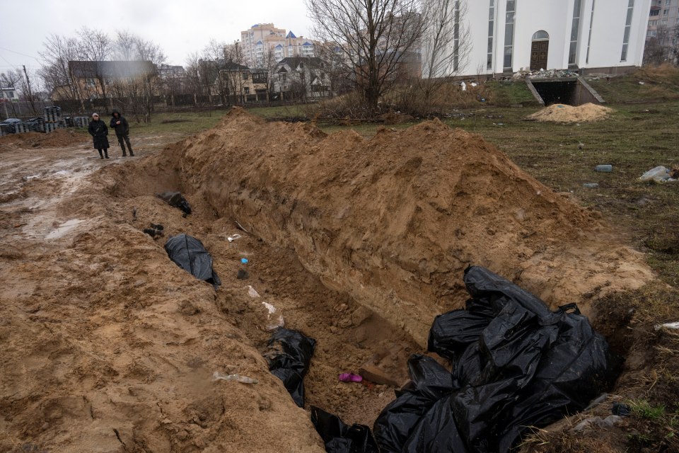 Neighbours gather next to a mass grave in Bucha