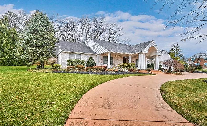 A horseshoe driveway leads to the home's front door