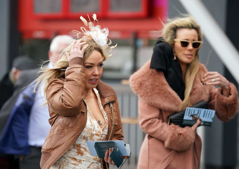 Visitors cling to their fascinators as they arrive at the course