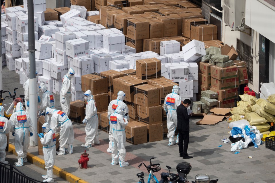 Firefighters wearing personal protective equipment (PPE) unload anti-epidemic supplies