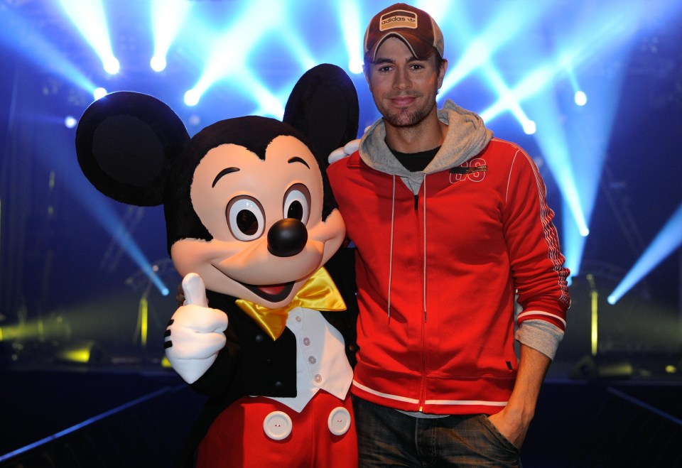 Enrique Iglesias posing with Mickey after a special showcase performance