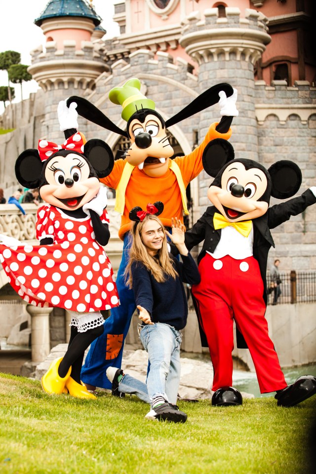 Cara Delevingne posing in front of Sleeping Beauty Castle