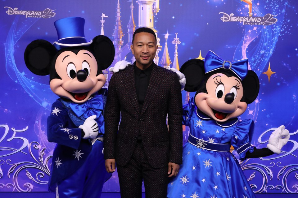 John Legend posing with Mickey and Minnie during the launch of the 25th Anniversary Celebration