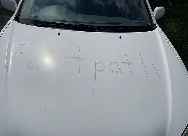 The word 'footpath' was left scrawled on an elderly couple's car has divided opinion