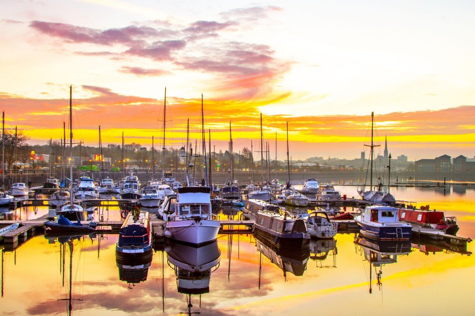 Calm sunny conditions at dawn as the sun rises over the leisure marine in the north-west of England