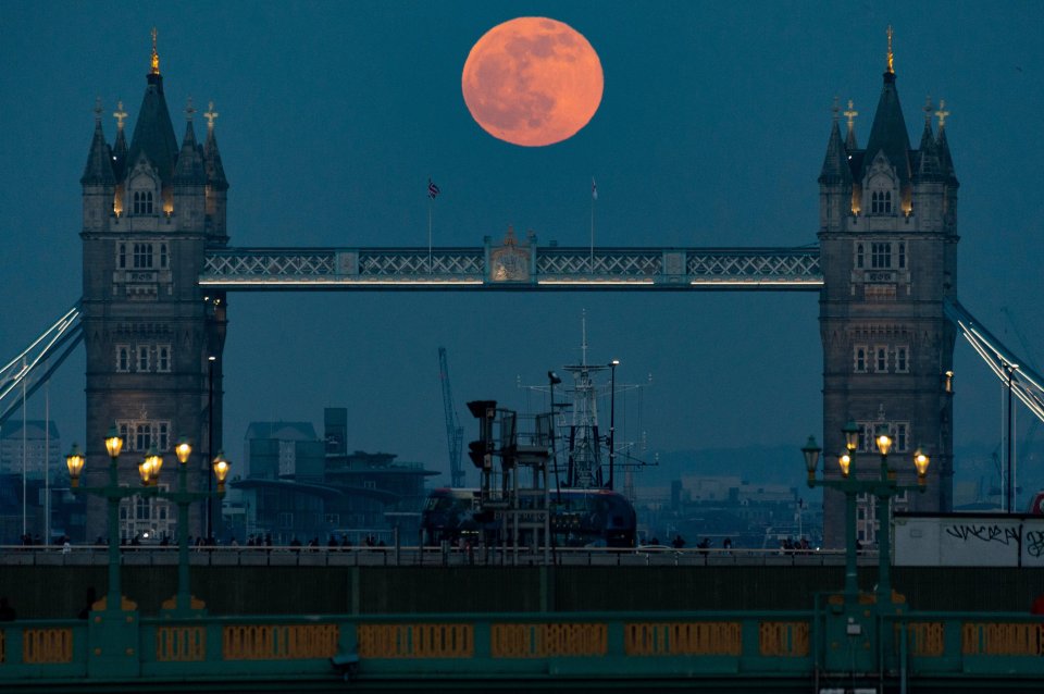 The full Pink Moon lingers over Tower Bridge in London on Saturday April 16, 2022