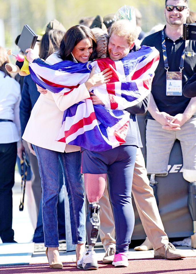 The Duke and Duchess of Sussex hug Team United Kingdom competitor Lisa Johnston