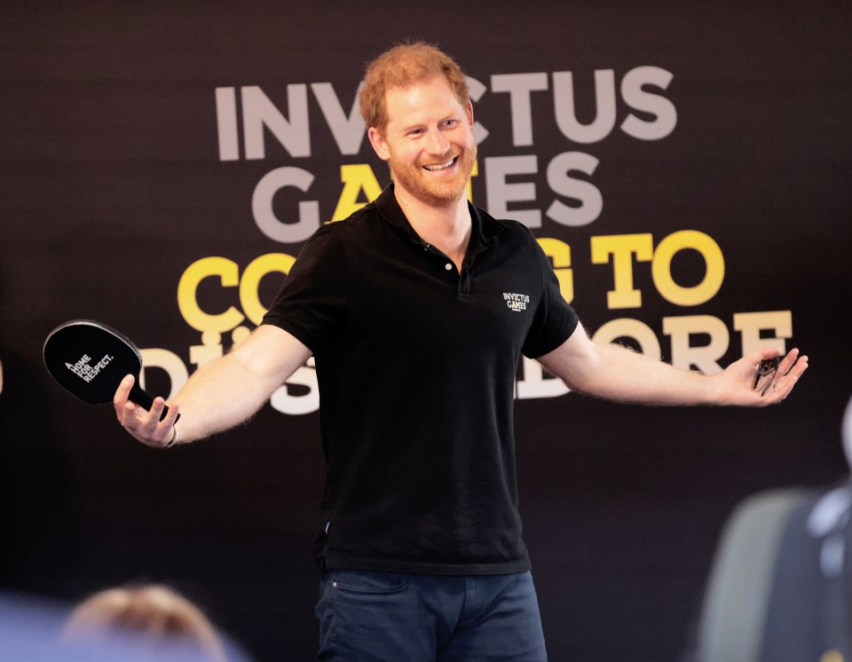 Prince Harry plays table tennis while on a tour of the Invictus Games venue