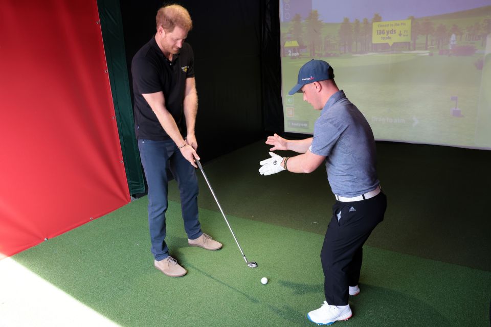 The Duke of Sussex was pictured swinging a club in a game of virtual golf