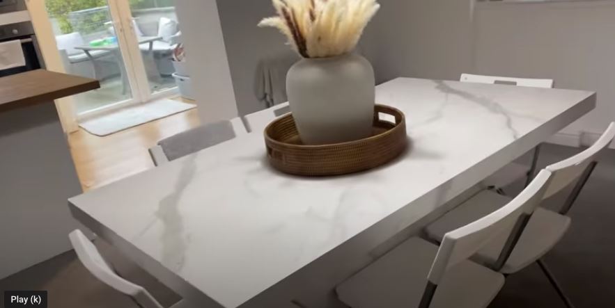 There is a huge white marble table in the kitchen