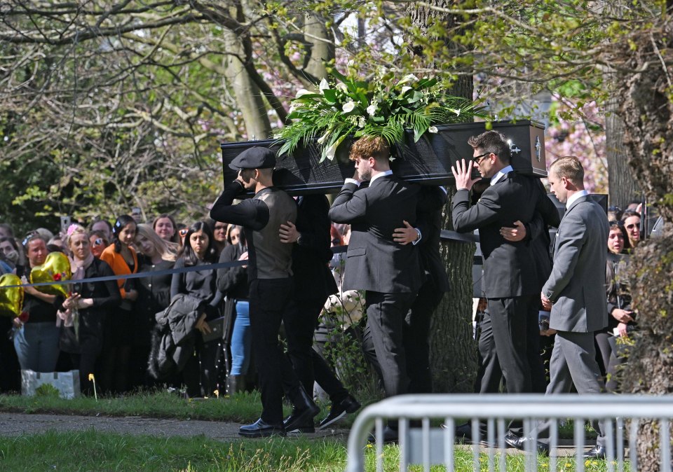 Fans watch on as the band carry Tom into the church