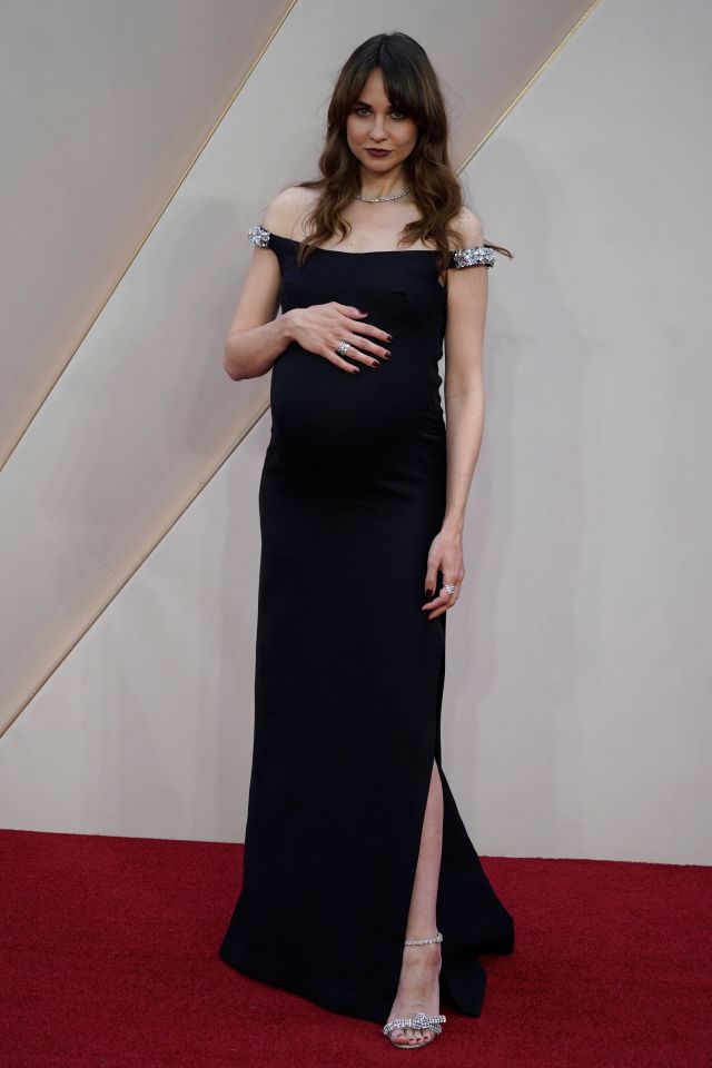 Tuppence cupped her growing belly as she posed on the red carpet