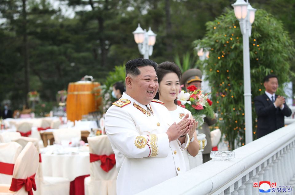 Kim along with his wife Ri Sol Ju stood on a balcony to watch the procession