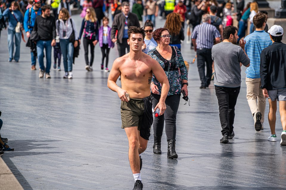 A shirtless man jogs in the baking heat in Potters fields along London riverside