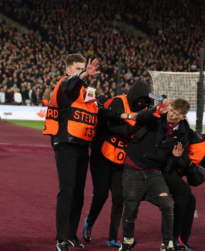 West Ham fans were the opposite of the smiling fan, as an airhorn was hurled towards him as he was escorted off the pitch