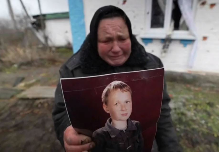 The grieving mum holding a picture of son Oleksei