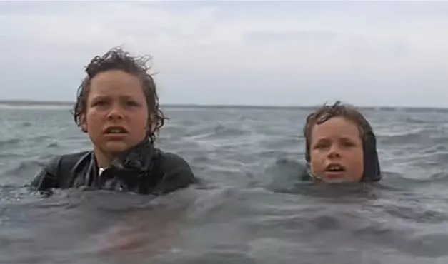 Jonathan (right) was nine when he was in a scene in which he and a pal, played by his brother, terrify beachgoers by swimming with a fake shark fin on his back