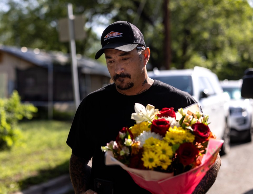 Joshua Dominguez from San Antonio, Texas brings flowers to the scene