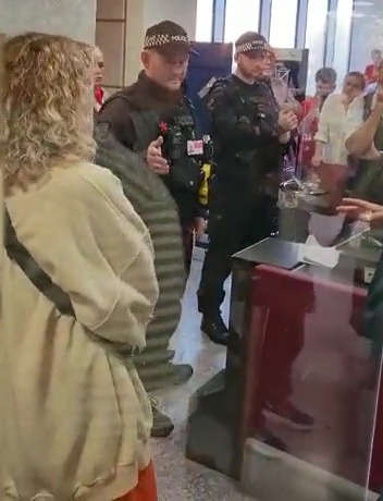 As tensions rose an armed cop stepped in to tell passengers who waited eight hours for a flight that it was cancelled