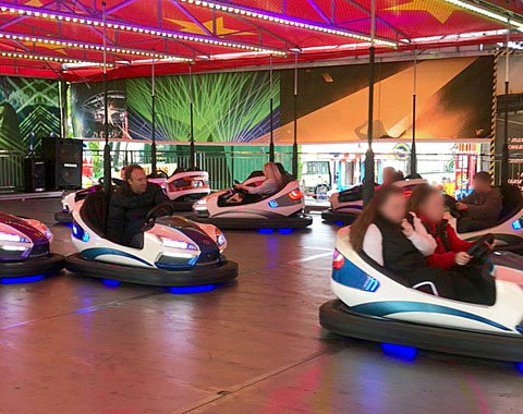 He whizzed around in the bumper car before greeting members of the public