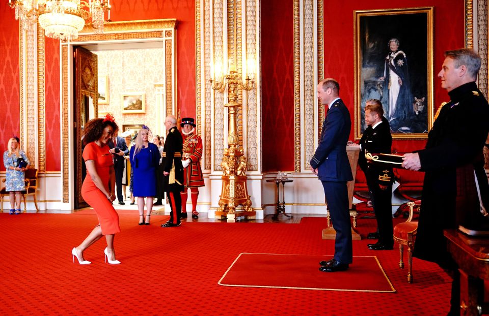 Mel B curtsying to Prince William before receiving her MBE