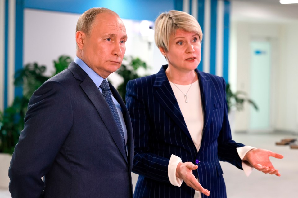 Putin looks puffy-faced as he speaks with head of the Talent and Success Foundation Yelena Shmelev, in Russia