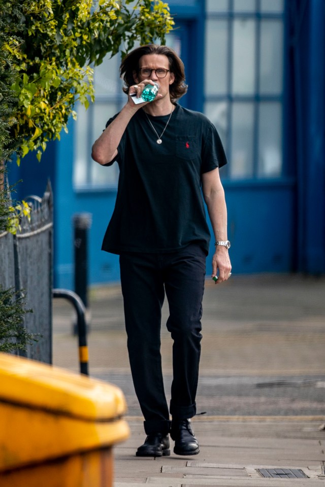 He showed off his long brown locks as he walked near his home