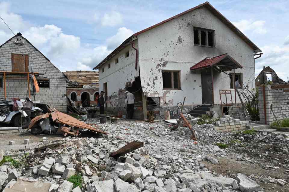 Locals examining the damage of a house in the village of Mala Rogan, Kharkiv, one of several regions recently liberated by Ukrainian troops