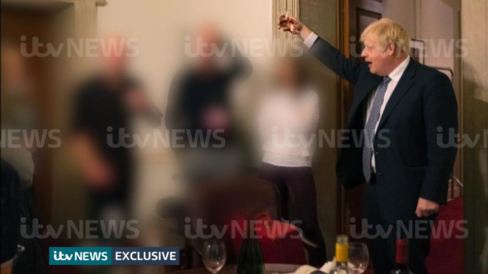 The PM is pictured leading a toast next to a group of colleagues during lockdown