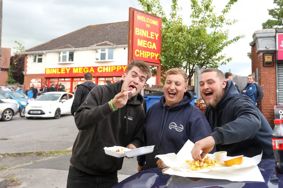 Three lads have a right laugh as they demolish their fish and chips at the chippy