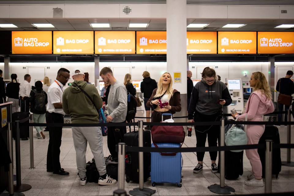 Travellers queue to check in for their EasyJet flights at Gatwick Airport