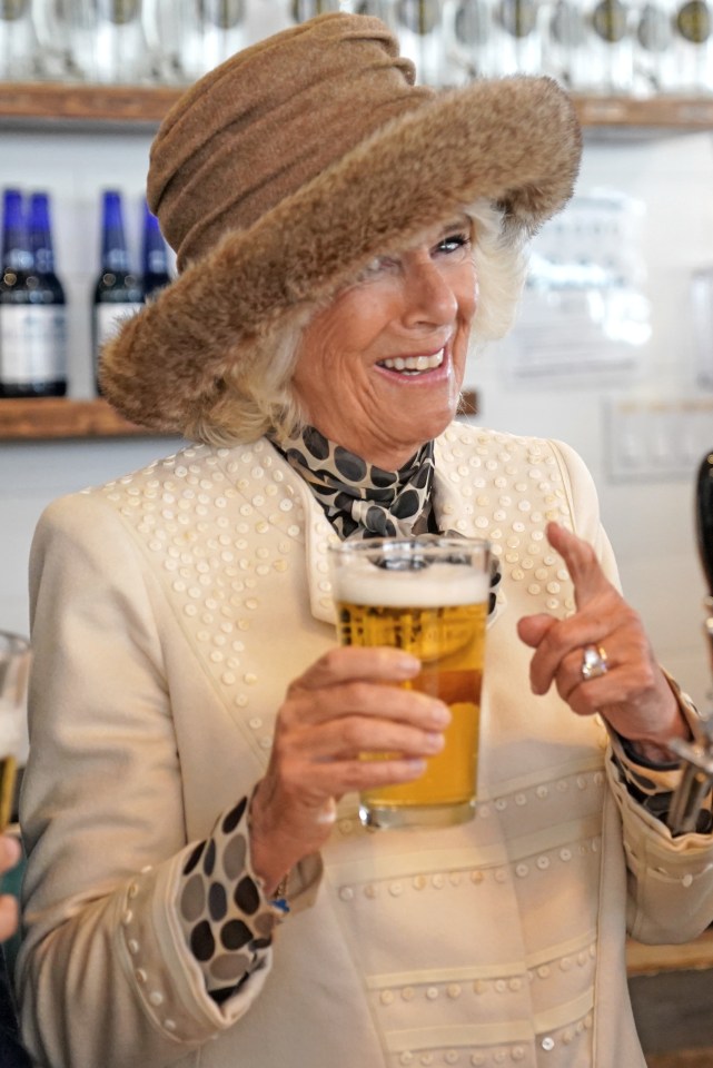 Charles was given a hand behind the bar by wife Camilla