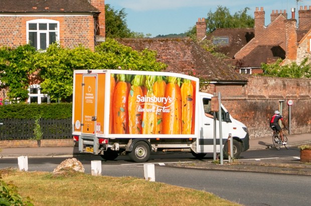 a sainsbury 's truck is driving down the road