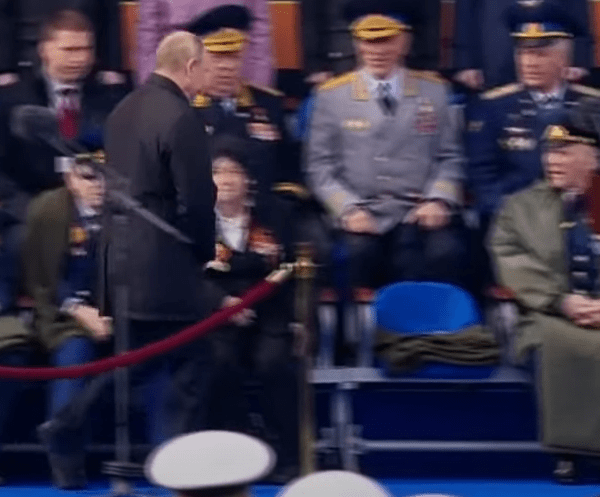 Putin arrives at his seat to pick up his blanket